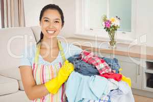 Composite image of laughing woman holding laundry basket