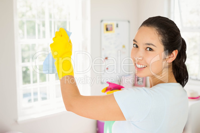 Composite image of smiling woman cleaning walls