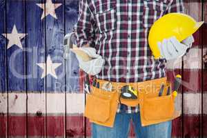 Composite image of handyman holding hard hat and hammer