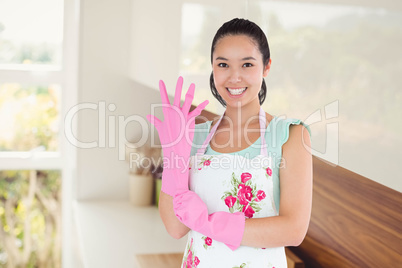 Composite image of woman putting on plastic gloves