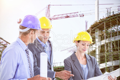 Composite image of businessman explaining a blueprint to his colleagues