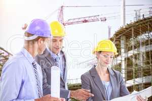 Composite image of businessman explaining a blueprint to his colleagues