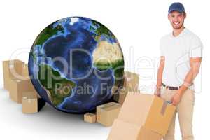 Composite image of happy delivery man pushing trolley of boxes