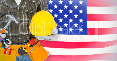 Composite image of manual worker wearing tool belt while holding hammer and helmet