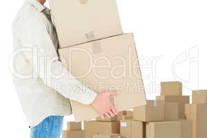 Composite image of delivery man carrying cardboard boxes