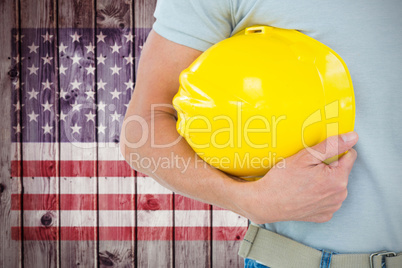 Composite image of technician holding hard hat