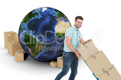 Composite image of happy delivery man pushing trolley of boxes Composite image of happy delivery man pushing trolley of boxes