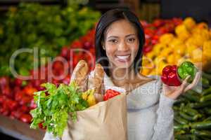 Woman holding vegetables in organic section