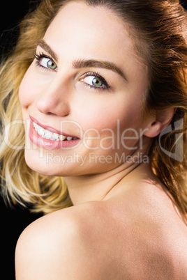 Portrait of beautiful woman smiling against black background