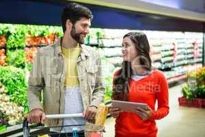 Couple using digital tablet while shopping