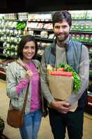 Couple shopping for vegetables in organic section of supermarket