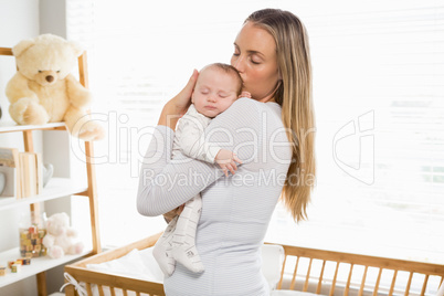 Mother holding and kissing her baby boy