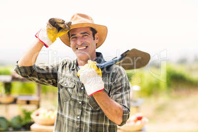 Portrait of farmer carrying shovel