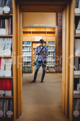 Student using digital tablet in library