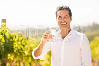 Portrait of smiling male vintner holding a glass of wine