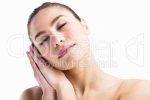 Woman posing with her eyes closed against white background