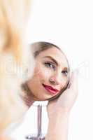 Reflection of beautiful woman in hand mirror