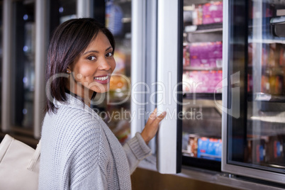 Woman standing near refrigerator