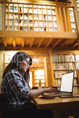 Female student using laptop in library