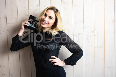 Beautiful woman posing with camera against texture background