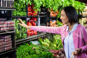 Woman buying vegetables in organic section