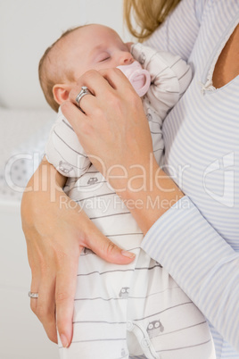 Mid-section of mother holding her baby boy