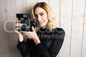 Woman holding a camera against textured background