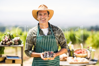Portrait of a smiling farmer holding box of fig