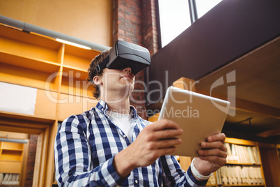 Student using digital tablet and virtual reality headset in library