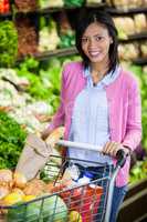 Woman holding trolley in organic section