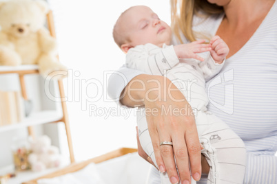 Mid-section of mother holding her baby boy