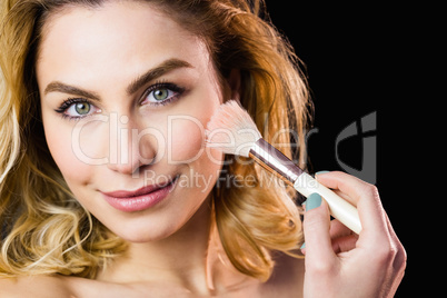 Portrait of beautiful woman posing with make-up brush