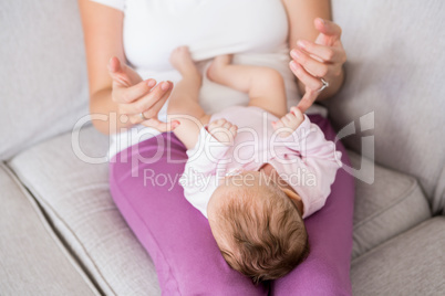 Mother playing with her baby in bedroom