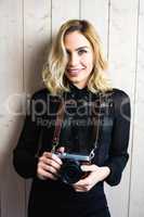 Beautiful woman holding a camera against textured background