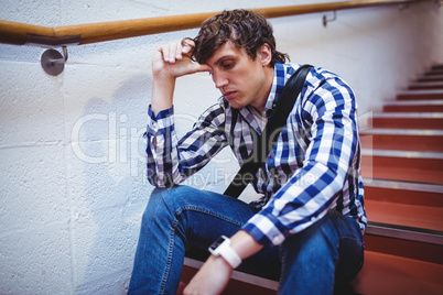 Upset student sitting on staircase
