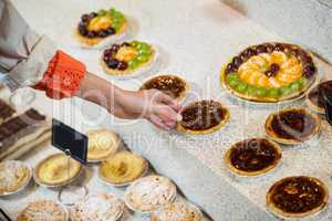 Woman selecting tart from display