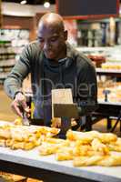 Smiling man purchasing bread