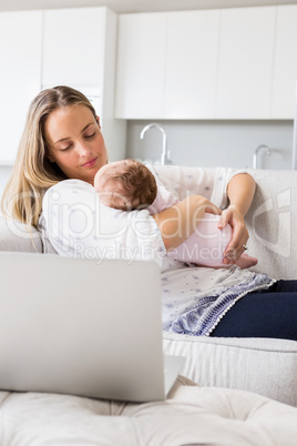 Mother carrying her baby in living room