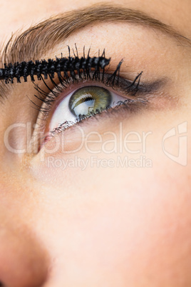 Beautiful woman applying mascara on eyelashes