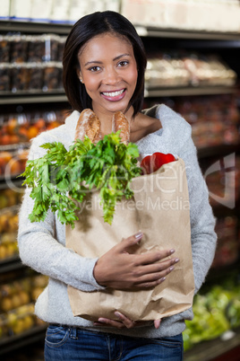 Portrait of smiling woman holding a grocery bag
