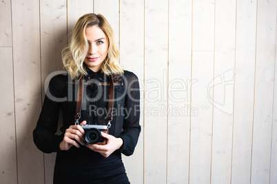 Beautiful woman holding a camera against textured background