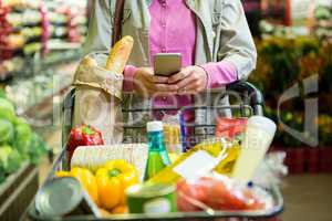 Woman using mobile phone while shopping
