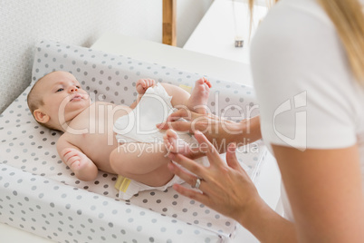 Mother changing the diaper of her baby