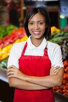 Smiling female staff standing with arms crossed in organic section