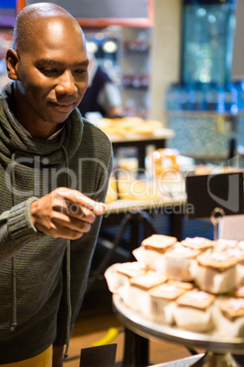 Smiling man purchasing sweet food