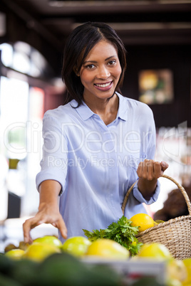 Smiling woman buying fruits in organic section