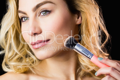 Beautiful woman posing with make-up brush