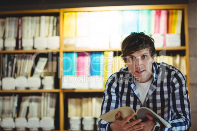 Student reading book in college library