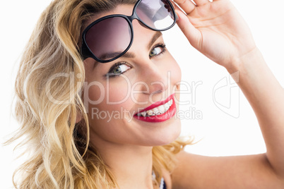 Portrait of beautiful woman posing with sunglasses against white background