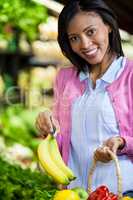 Woman buying banana in organic section